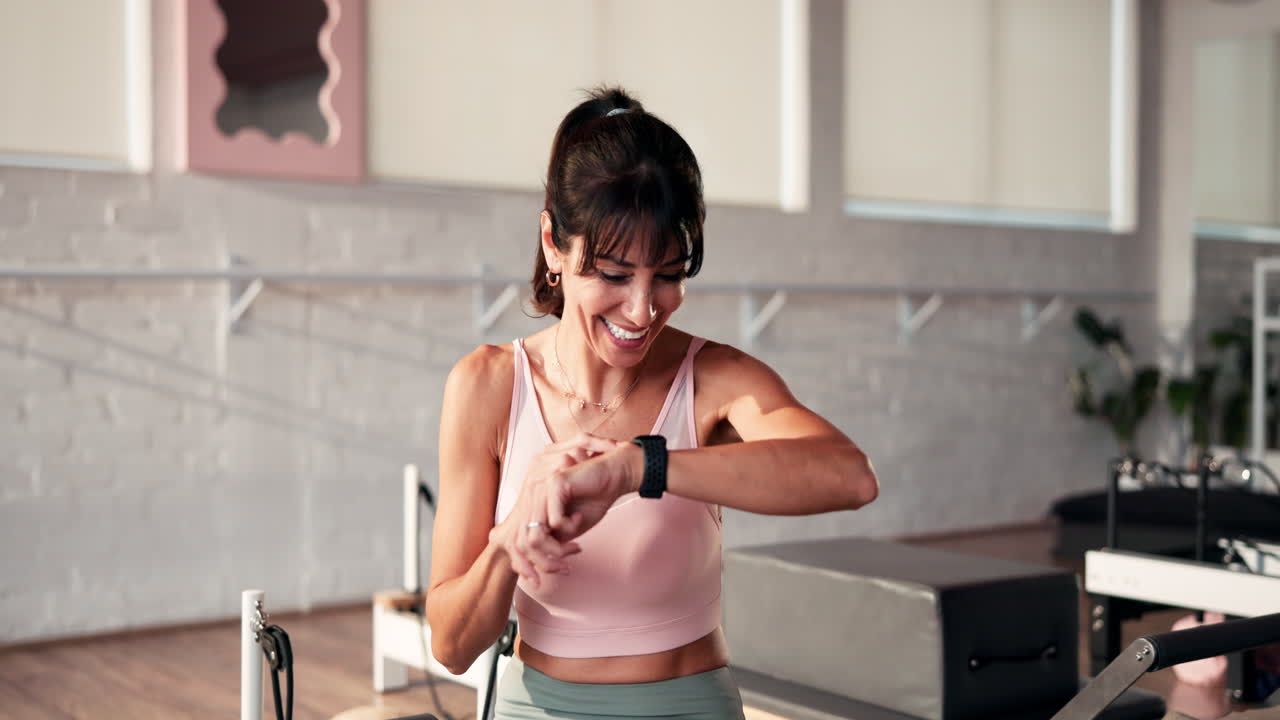 Donna che controlla lo smartwatch durante l'allenamento di pilates