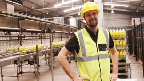 retrato de un trabajador de pie con las manos en la cadera en una fábrica