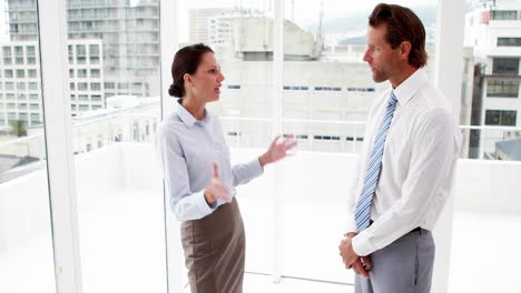 business team arguing by large window