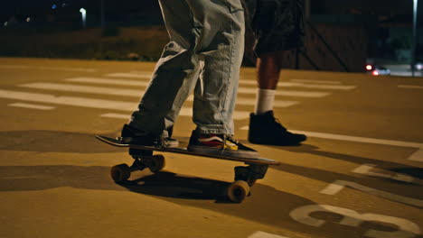 amores adolescentes montando patinaje por la noche de cerca. hombre abrazando a su novia amorosa