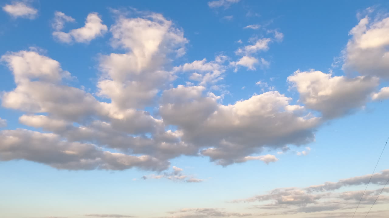 Formation of cumulus cloudscape in the atmosphere. Low angle timelapse of little soft clouds in the sky.
