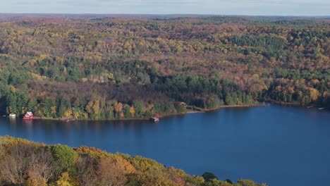 dorset lookout tower in ontario surrounded by fall foliage and a blue lake , aerial view
