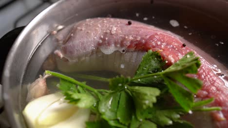 stuffed flank steak in pot with water and parsley for boiling