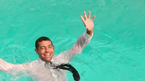 hombre de negocios vestido en la piscina