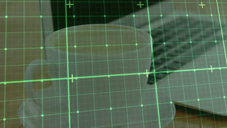 White ceramic coffee cup sitting near laptop and smartphone while green HUD grid overlay pulsating