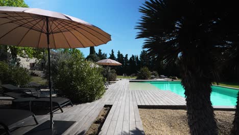 slow revealing shot of a private pool with sun loungers within a villa in nimes