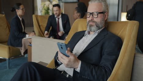 businessman using mobile phone in hotel lobby