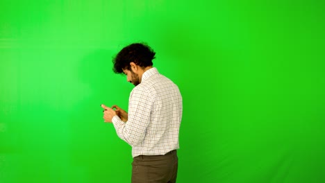 guy-using-mobile---tablet-with-green-screen-and-green-background-indian-guy-with-green-screen