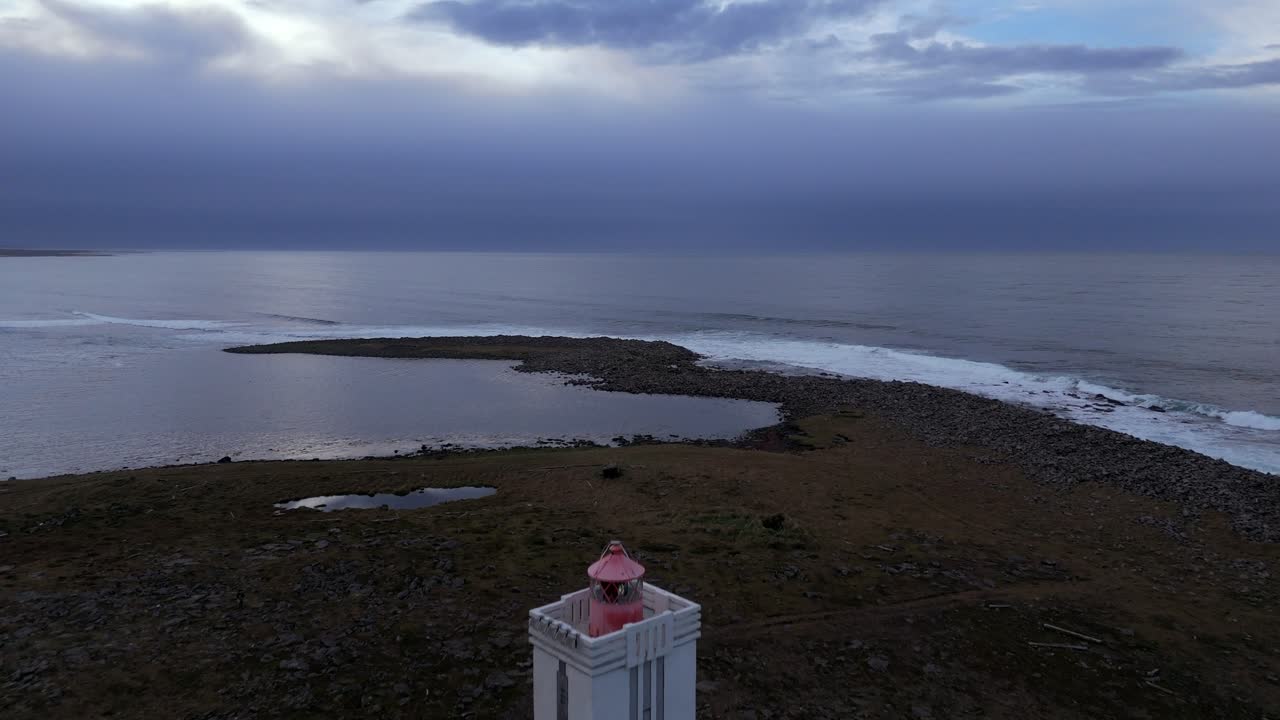 Iconic light house at Melrakkaslétta peninsula, Raufarhöfn, the most northerly peninsula in Iceland. Drone aerial fly over overlooking the Arctic Circle. Miniature perspective