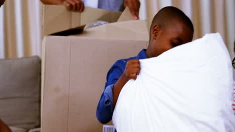 parents and kids opening cardboard boxes in living room