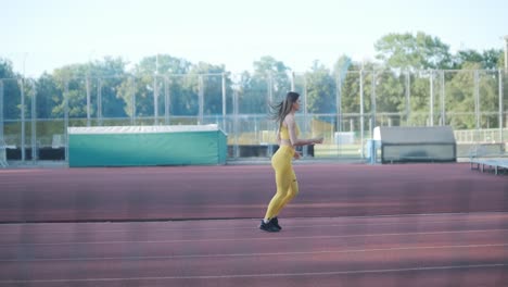 woman running on outdoor track in yellow sportswear