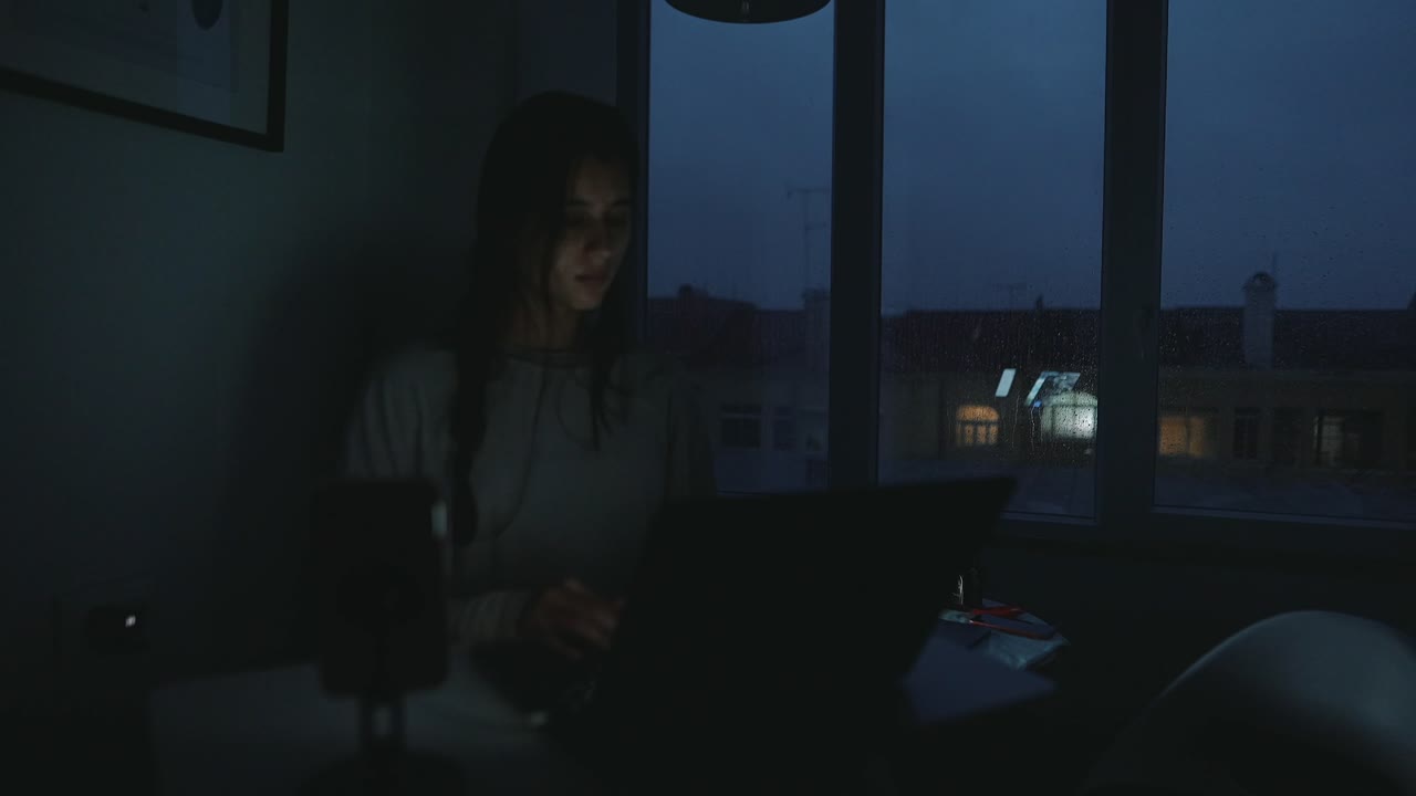 Woman working on a laptop at night