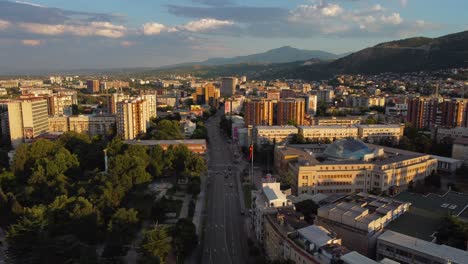 drone view of skopje cityscape with mountains and macedonia flag at sunset - macedonia