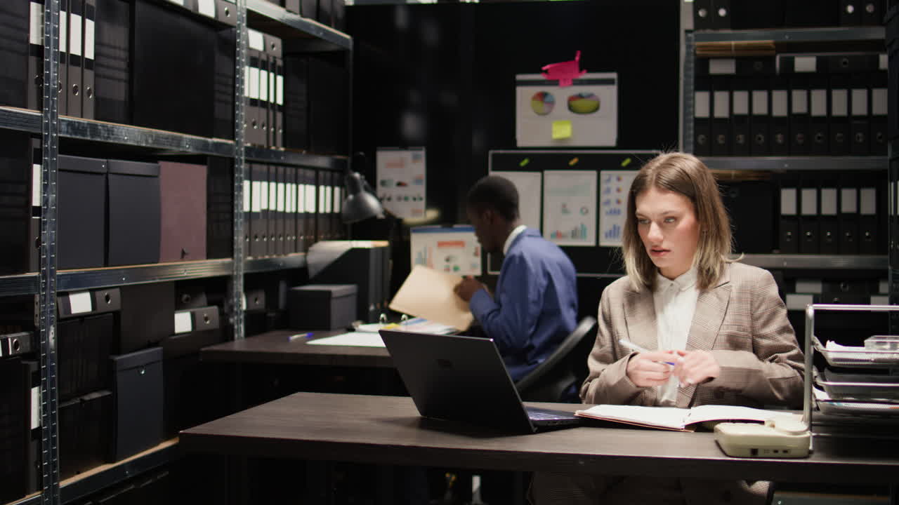 People working in an office surrounded by files and paperwork