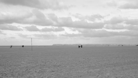 gente caminando en la playa de arena en la costa de deauville en normandía, francia