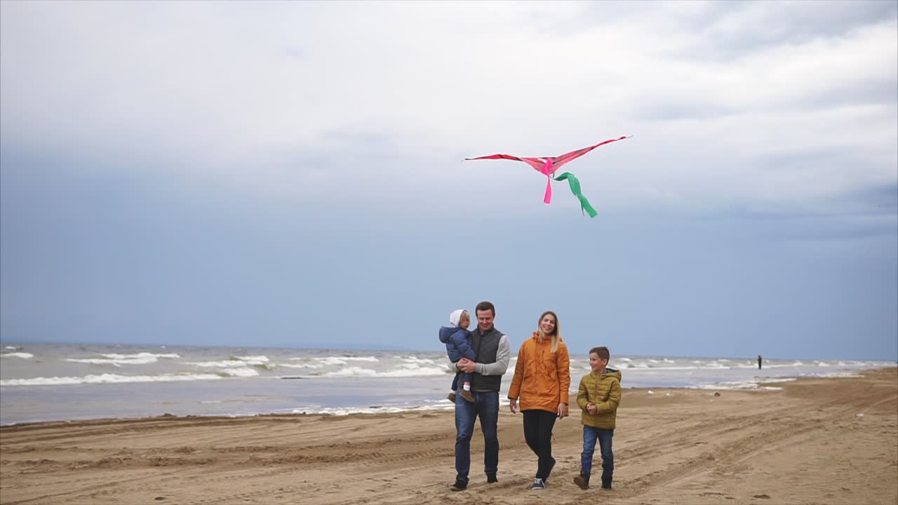 Family enjoying a beach walk with a kite