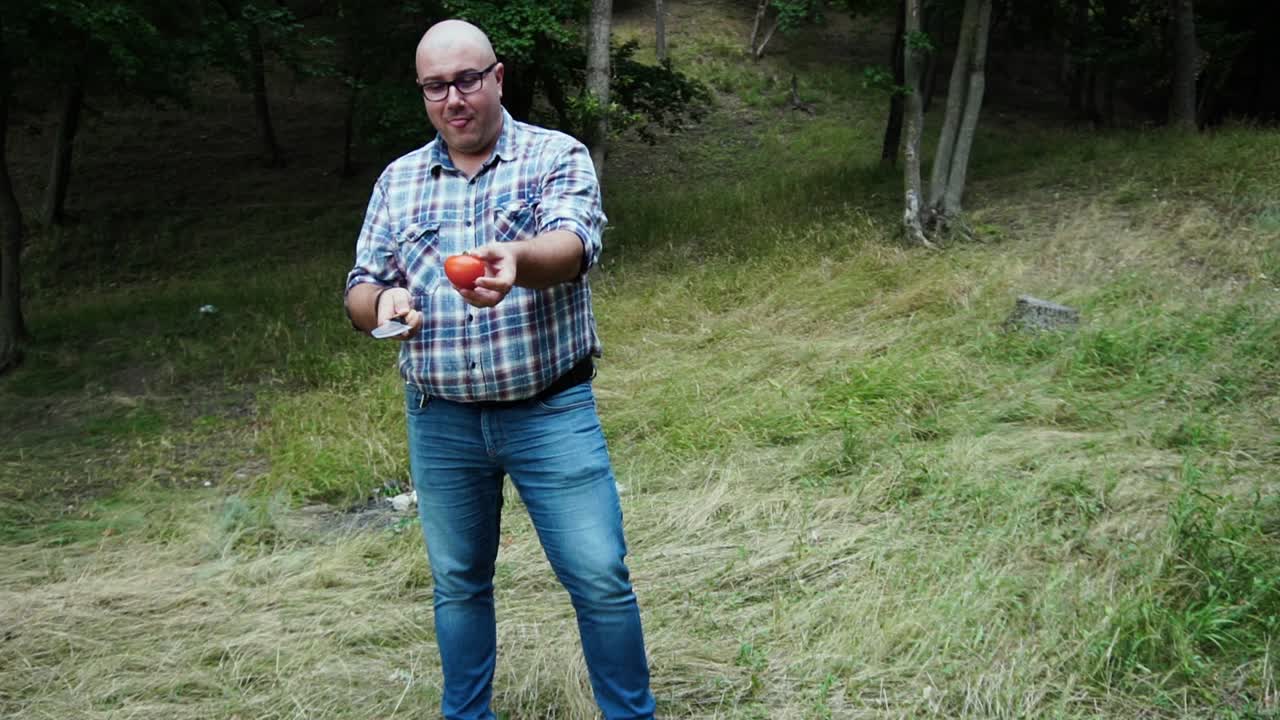 chef cortando tomate maduro con un cuchillo especial en cámara lenta de aire