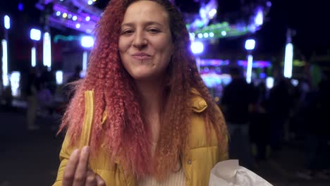 vrouw die churros eet op de kermis 's nachts