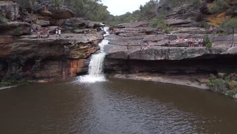 aerial footage of people jumping into waterfall