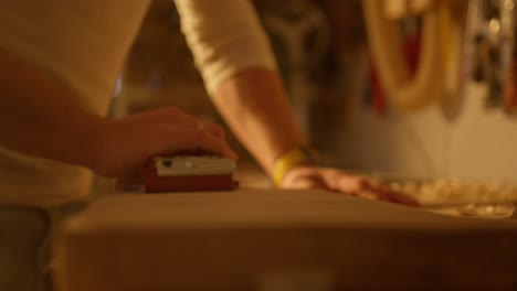 Close-up-of-human-hand-filing-a-piece-of-wood-with-repetitive-movements