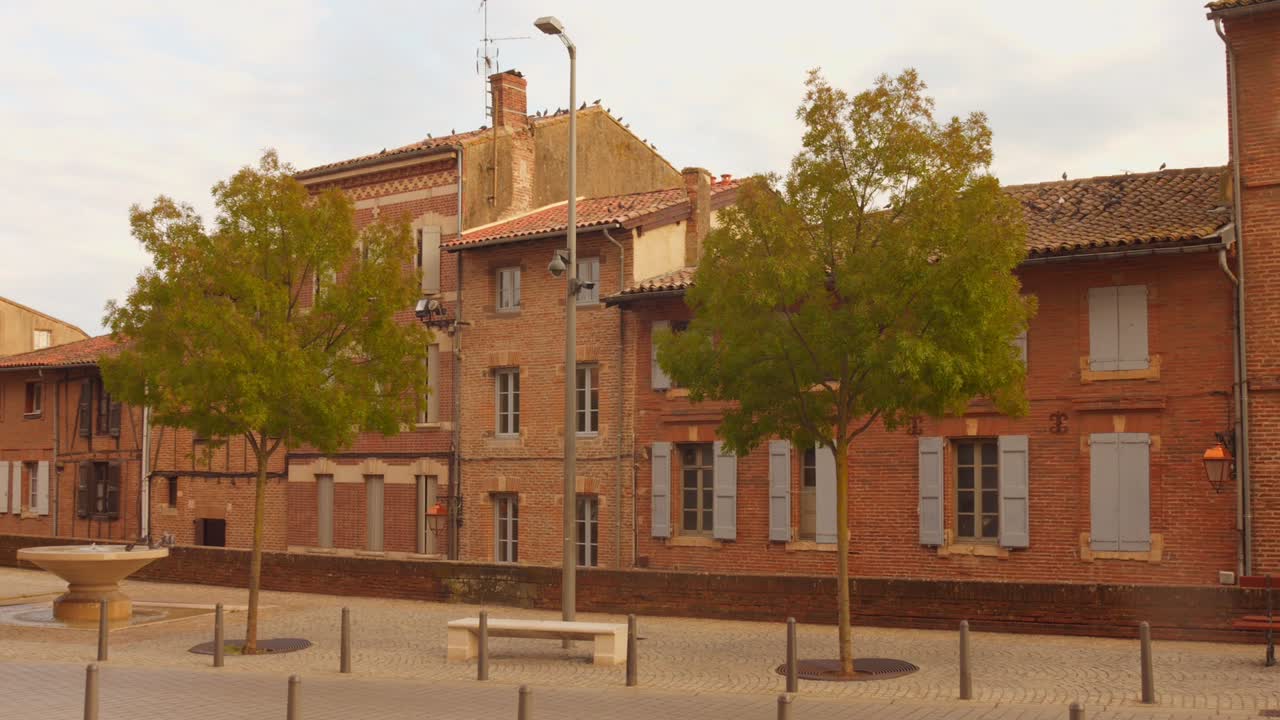 A charming and tranquil scene in Albi's historic center, showcasing the unique reddish-brown brick architecture of the Occitania region. Ideal for travel, history, or European city break projects