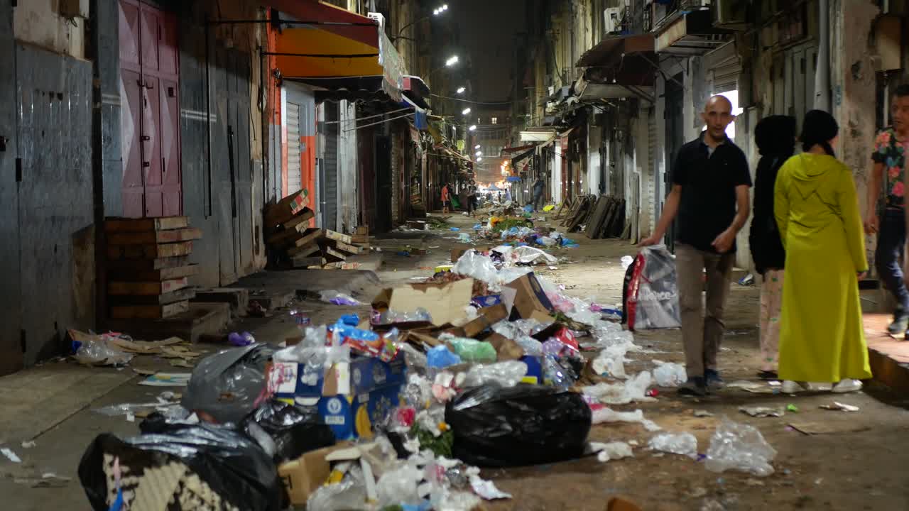 Aftermath of a street market at night, garbage scattered on the ground