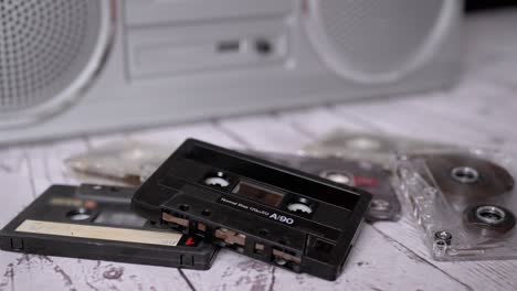 female hand picks up one old music audio cassette from the 90s from the table