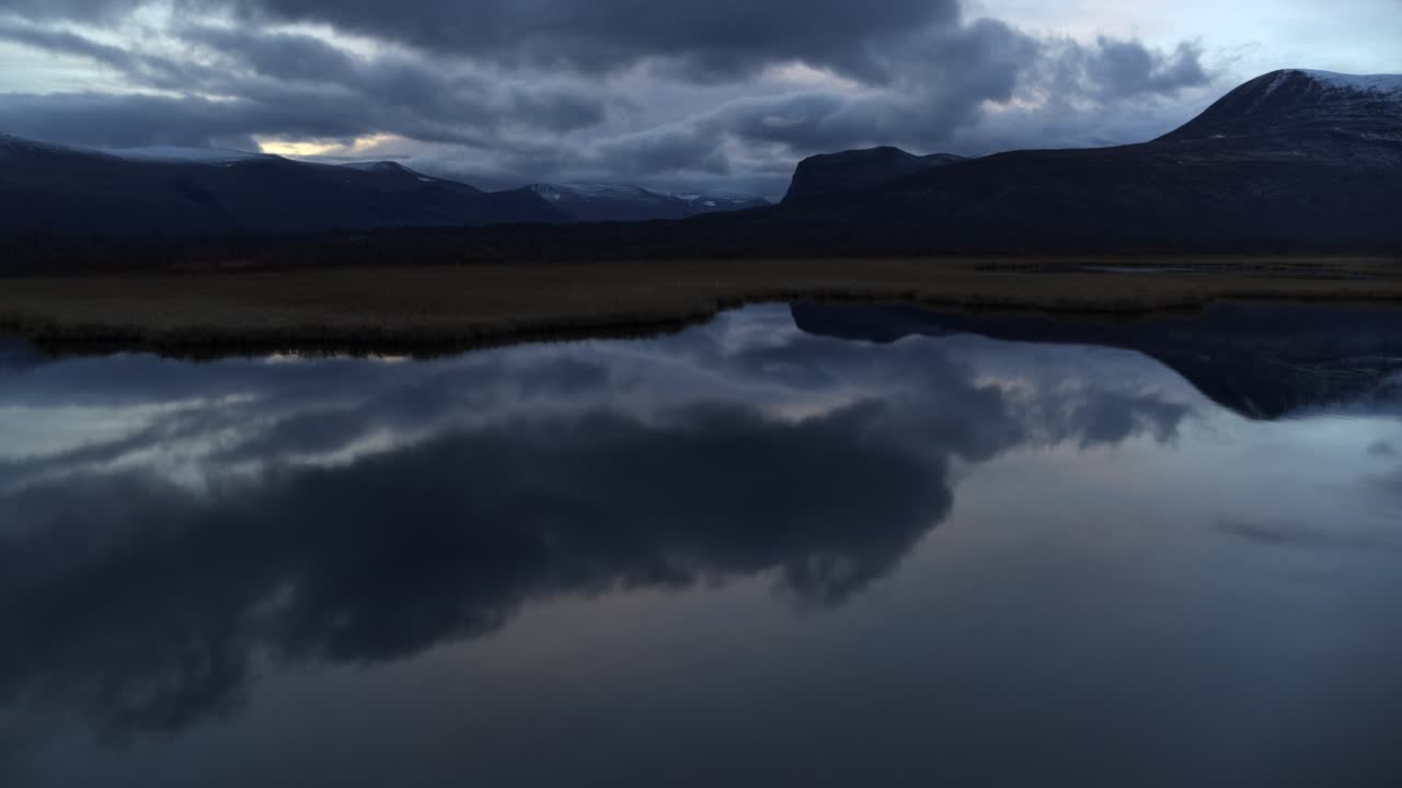 aerial forward sobre el lago reflectante en laponia, suecia en la noche, cinematográfico