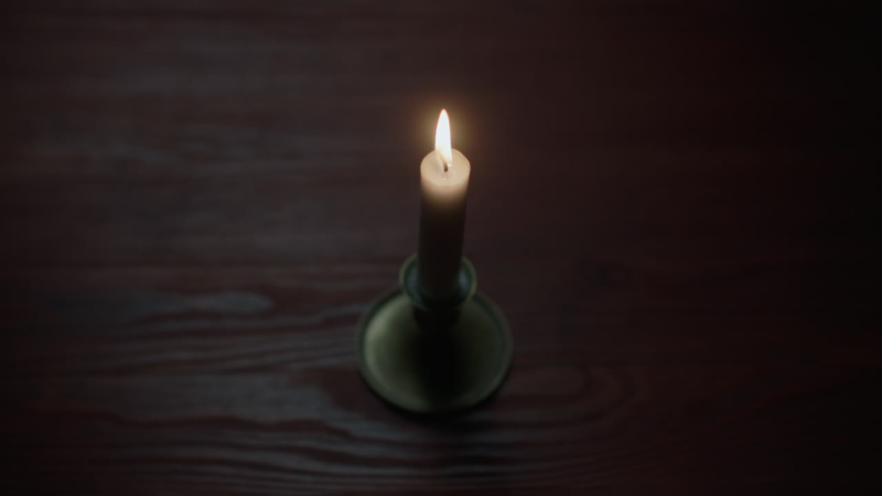 A candle burs out in the dark room