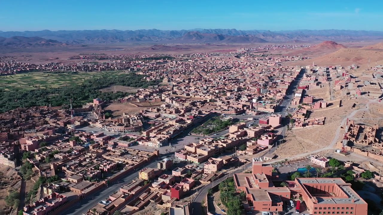 Veduta aerea con drone di Ouarzazate, che evidenzia il suo ingresso urbano, gli ampi viali e la posizione strategica tra le montagne dell'Atlante e il deserto marocchino