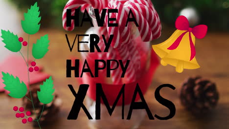 animation of have a very happy xmas text over candy canes and decorations on wooden background