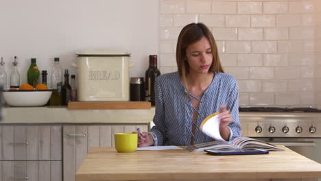 woman researching and making notes at kitchen table, lockdown, shot on r3d