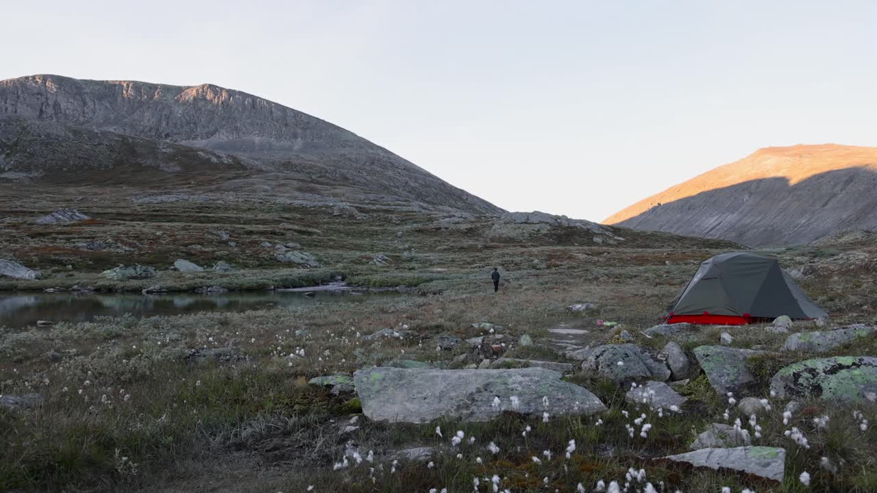 단독 남성 배 여행자 가을 스칸디나비아 드라 풍경에서 텐트 앞에서 하이킹