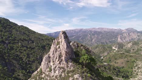 aerial view in orbit of a high mountain peak and parallax effect with mountains and mediterranean forest in the background