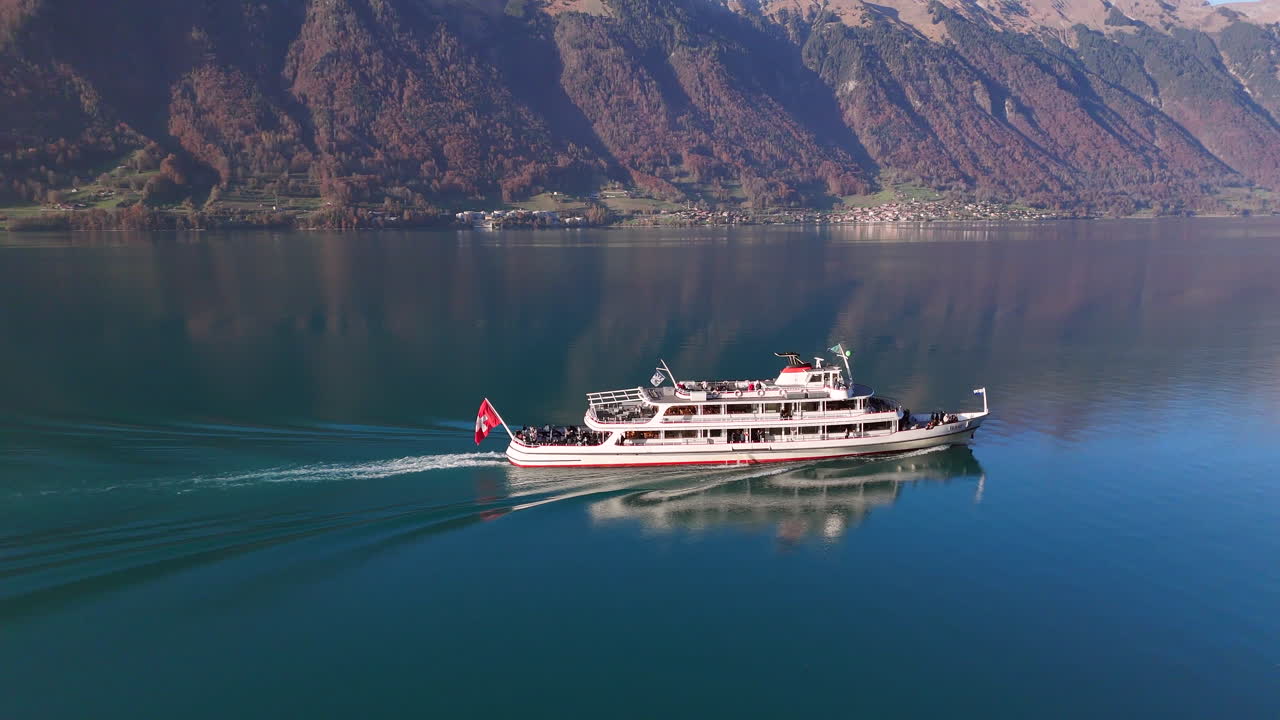 Aerial View of a Passenger Ship Cruising on a Calm Lake Surrounded by Majestic Mountains