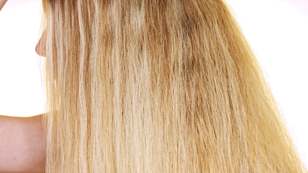 긴 생머리를 가진 아름다운 금발 여성이 천연 브러시로 빗질한다