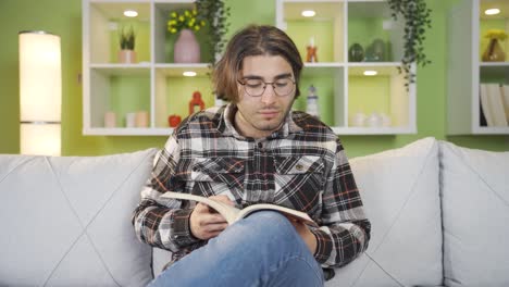joven estudiante con gafas leyendo un libro.
