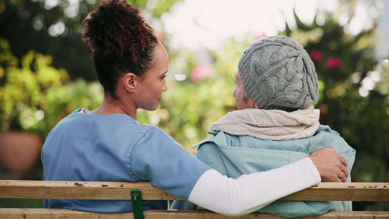 Caregiver Supporting Elderly Woman on Bench