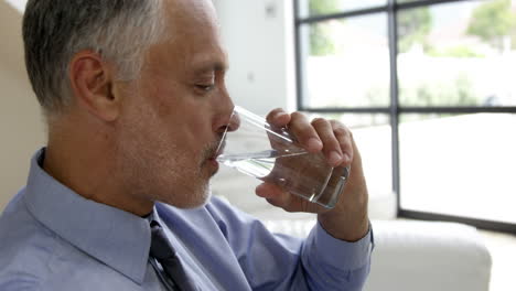 man drinking water glass