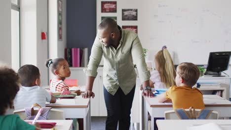 video of happy african american male teacher during lesson with class of diverse pupils