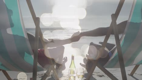 Animation-of-happy-african-american-couple-in-sunbeds-holding-hands-on-beach