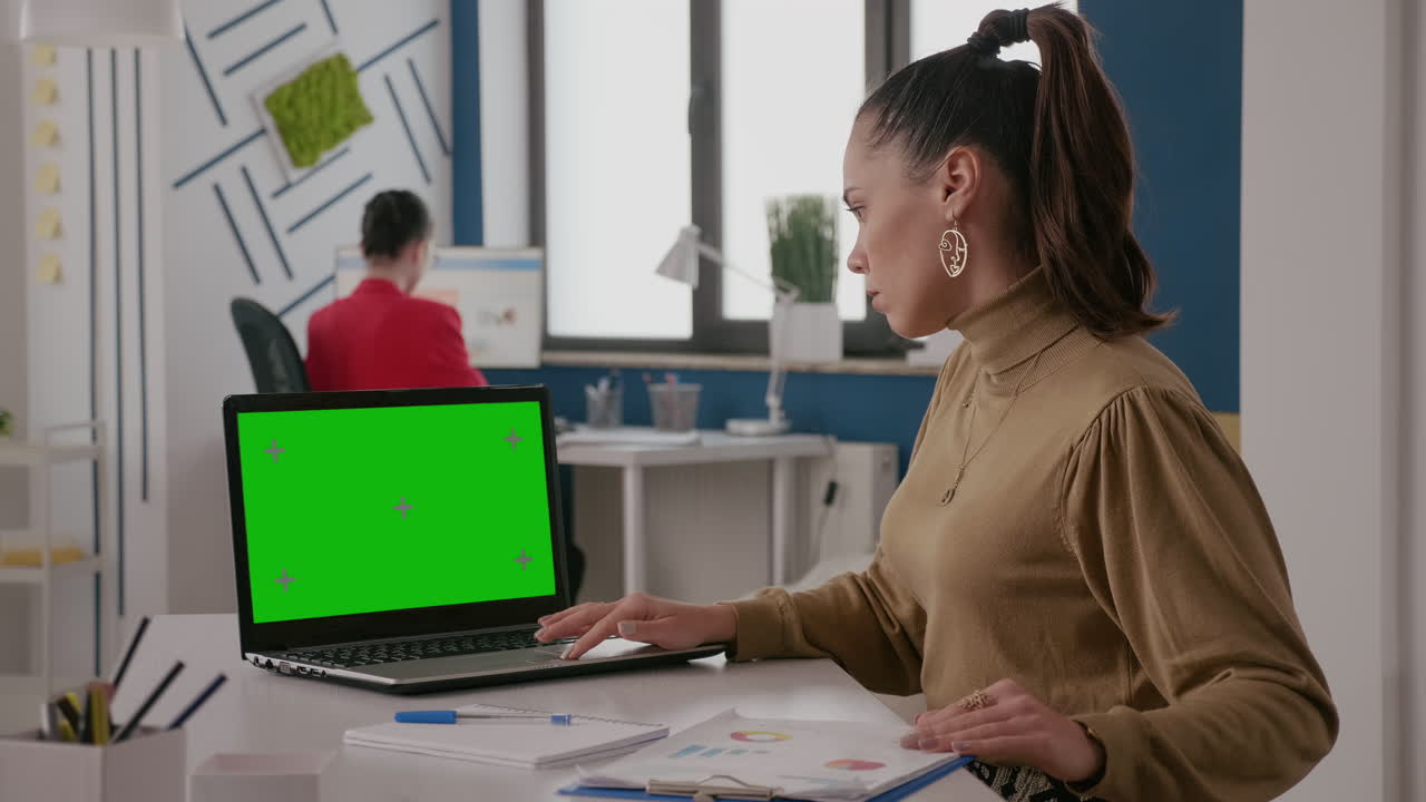 Business woman working with green screen on laptop