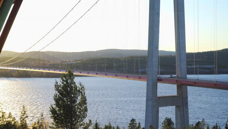 Vista-Panorámica-De-Un-Coche-Que-Circula-Por-Un-Puente,-En-Una-Tarde-Soleada,-En-Hoga-Kusten,-Vasternorrland,-Suecia