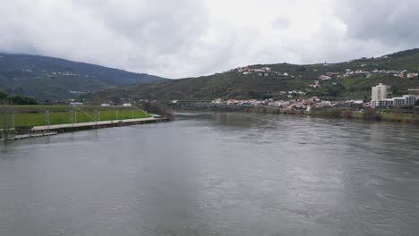 Río-Duero-Fluyendo-Por-Peso-Da-Regua,-Portugal---Sobrevuelo-Aéreo