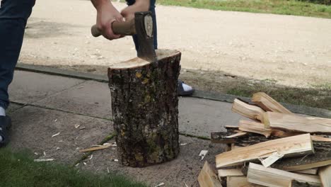 young man is chopping wood in smaller pieces