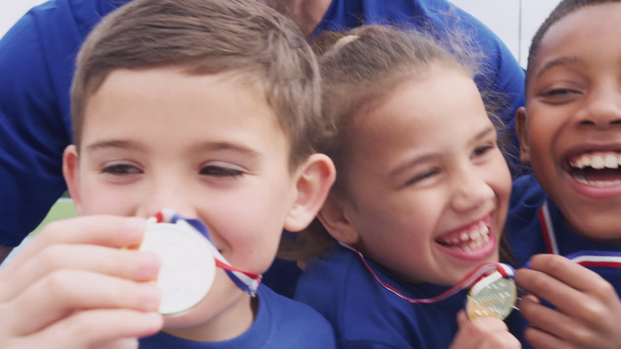 I bambini con l'allenatore mostrano le medaglie dei vincitori nella Giornata dello Sport