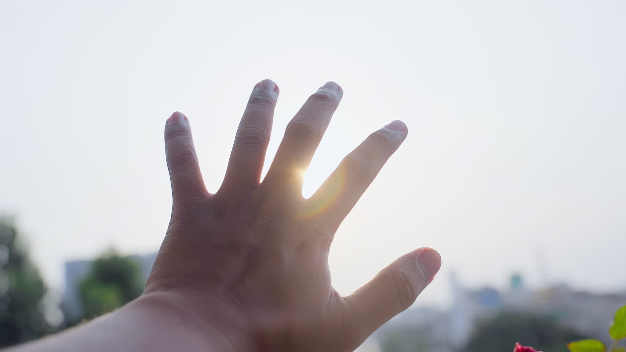 남자는 태양 아래에서 손을 뻗는다