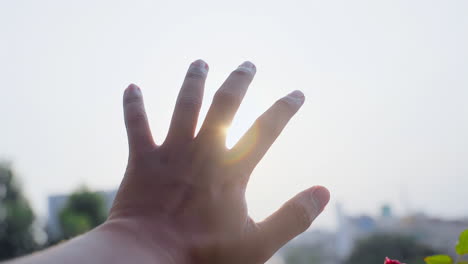 el hombre extiende su mano al sol
