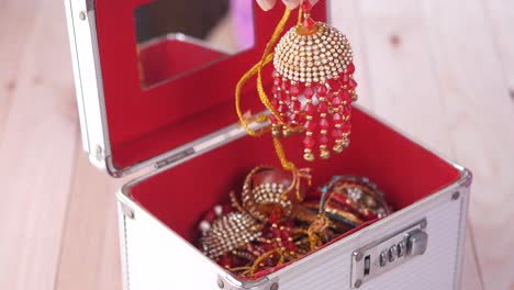 woman opening jewelry box with traditional indian ornaments