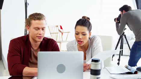 Photographer-and-female-model-discussing-over-laptop